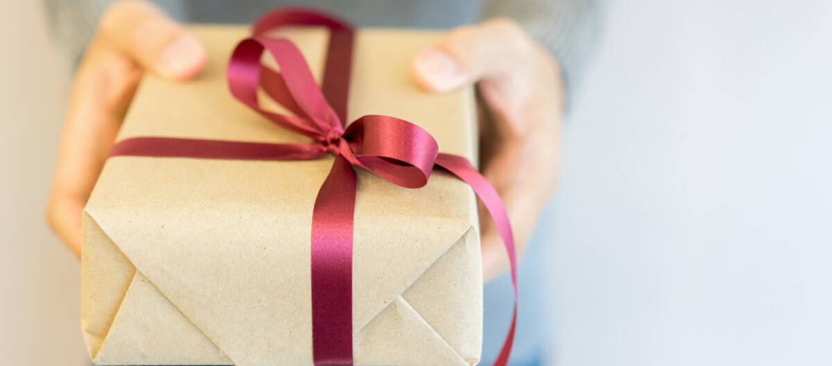 Weihnachtsgeschenke für Geschäftspartner:Ein Mann mit einem Geschenk in der Hand