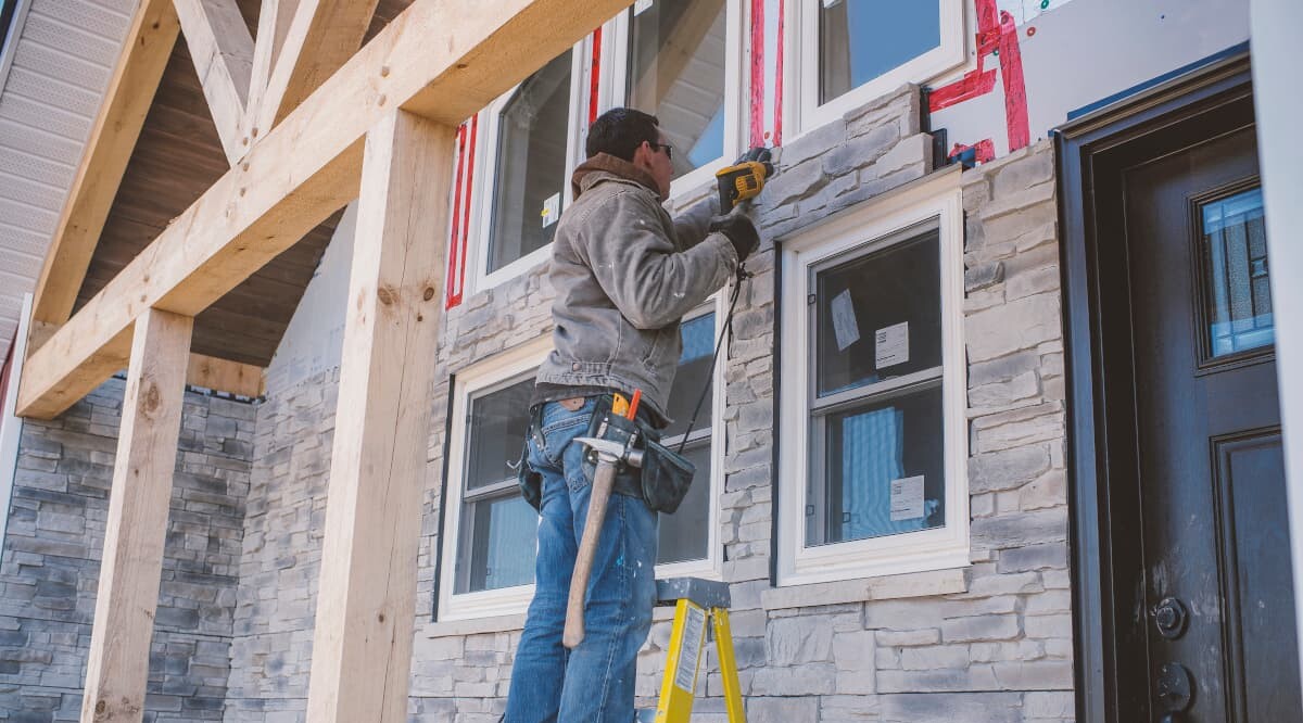 Bauarbeiter kachelt Fassade eines Hauses